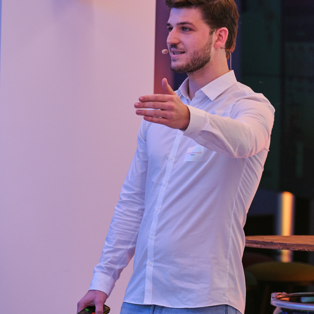 Mann in weißem Hemd spricht aktiv über Serious Games, eSports und Simulationsspiele.